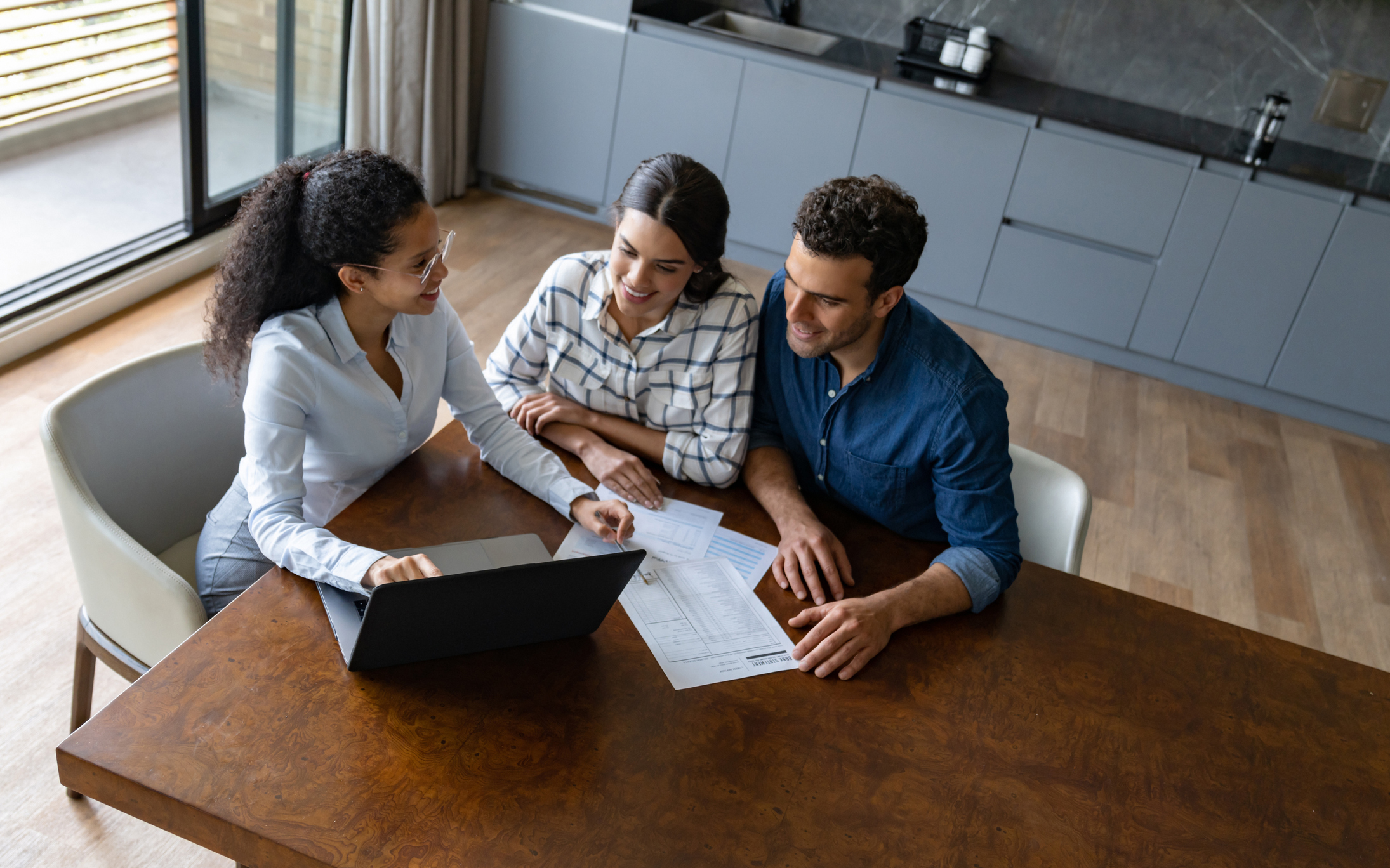 Financial advisor talking to a Latin American couple about their home finances - business concepts